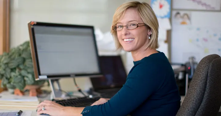 A WestCraft customer service representative at her desk, working at a computer