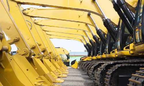 A row of tracked excavators lined up on a yard — representative of the earthmoving fleet that feeds screening and aggregate operations