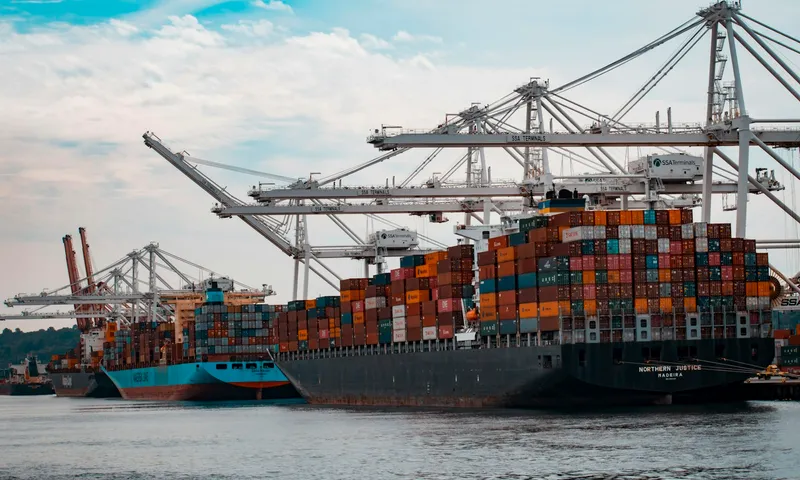 Cargo ship loading containers under gantry cranes at a shipping port